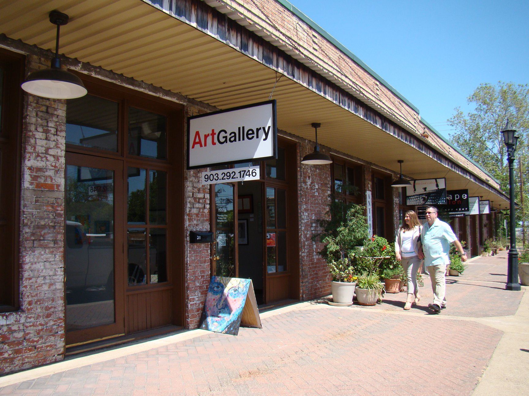Couple walking past shops downtown.